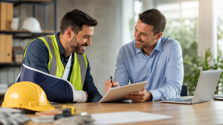 Workers compensation insurance meeting with an injured construction worker and advisor reviewing claim paperwork